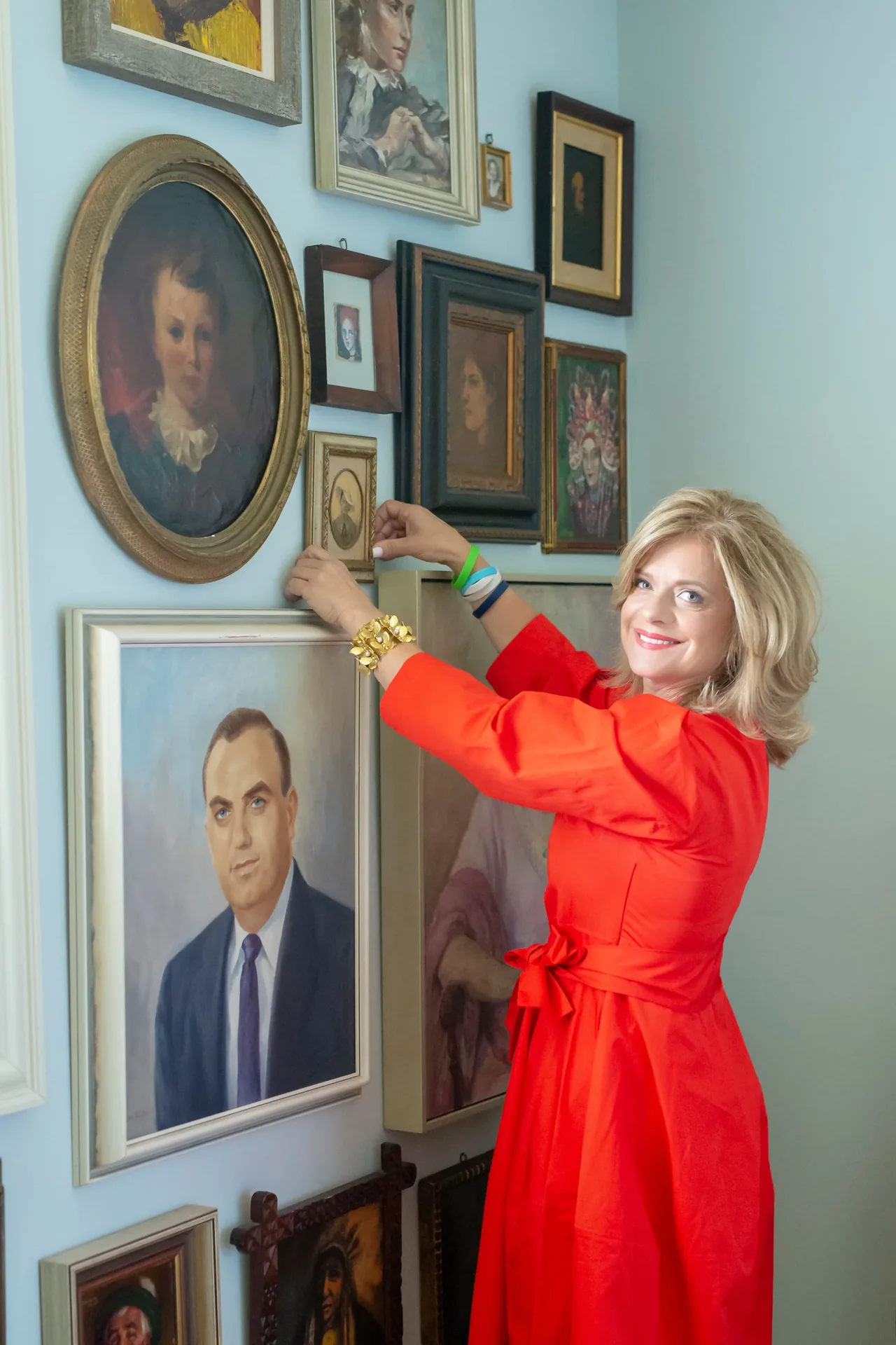 Maxine Sims arranging framed art