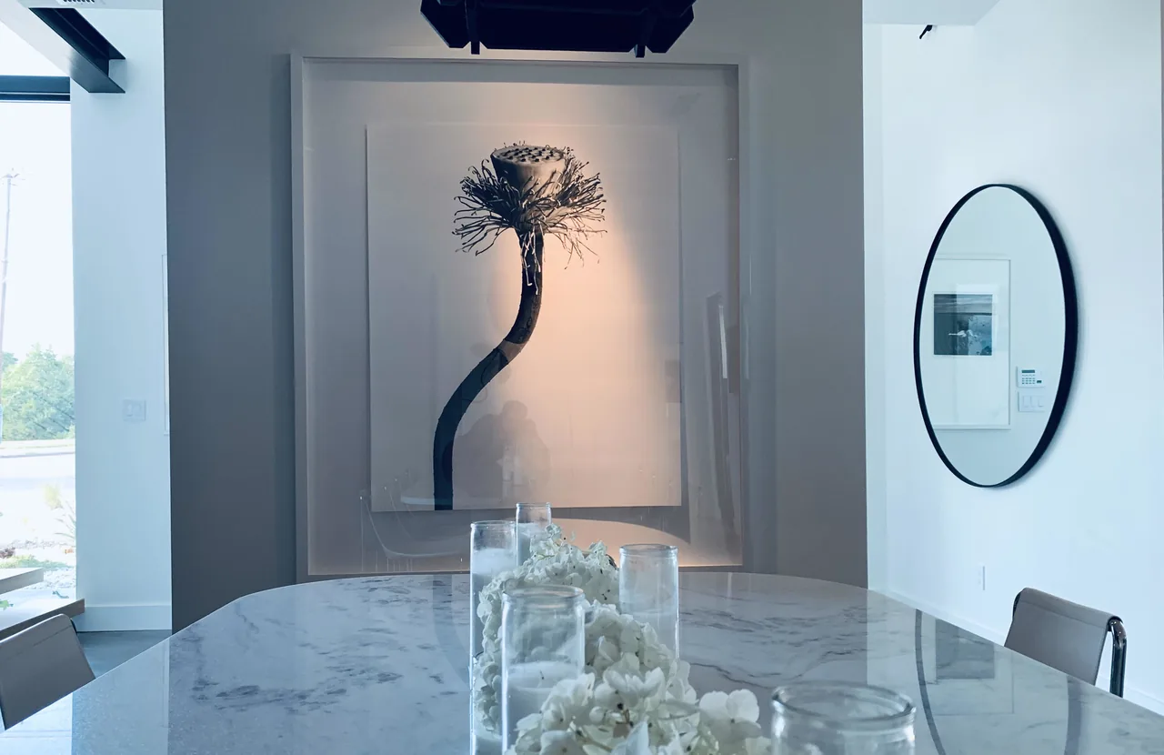 Contemporary dining room with sculptural art and custom mirror