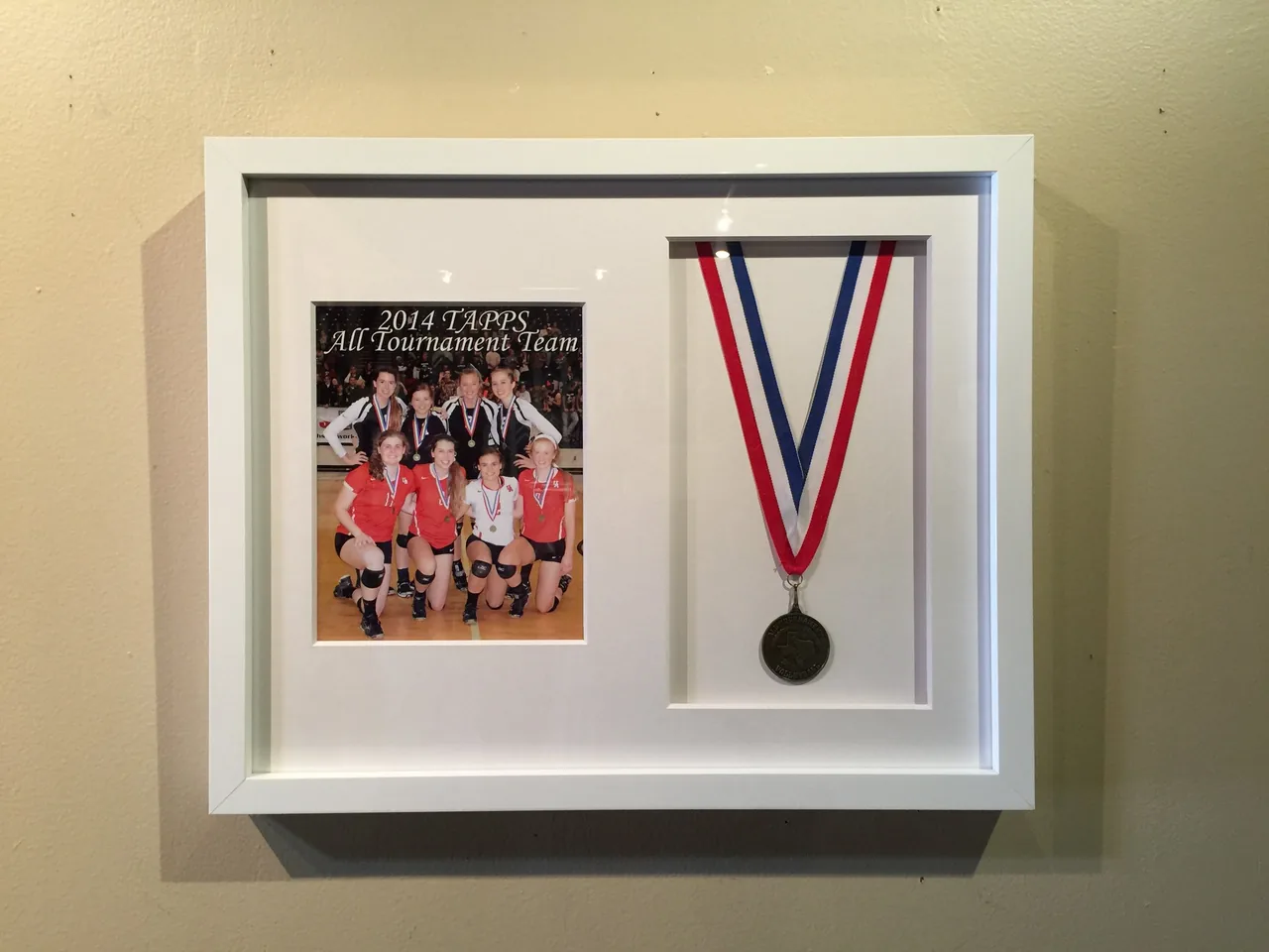 A medal and team photograph framed together