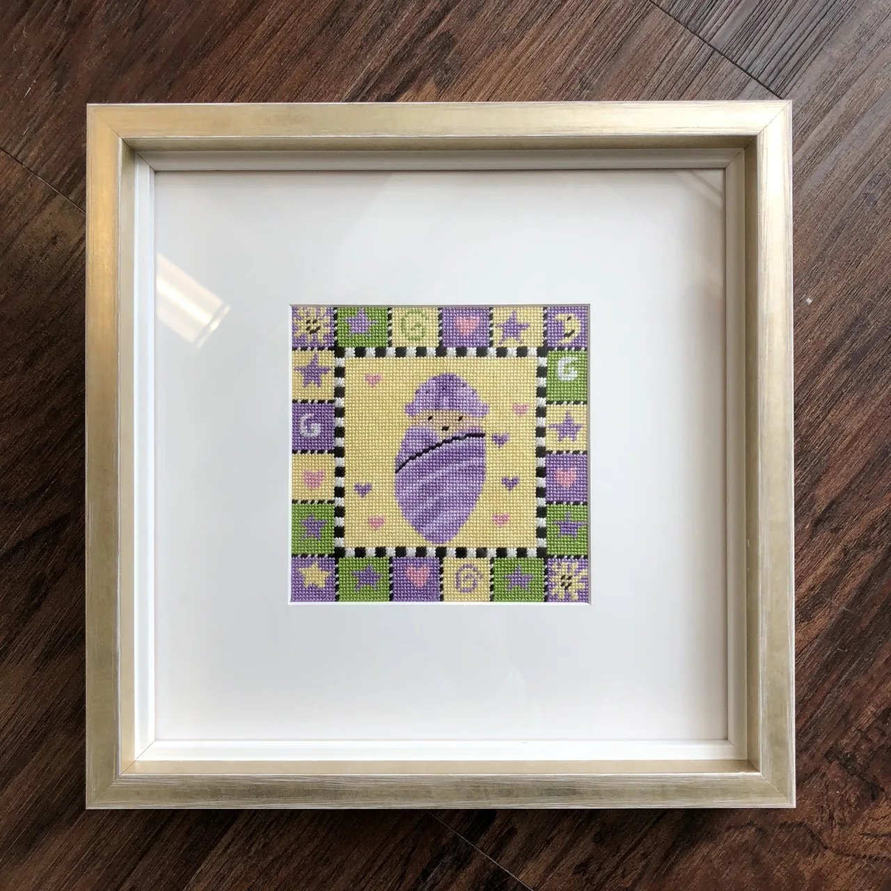 A small geometric artwork in a deep white mat